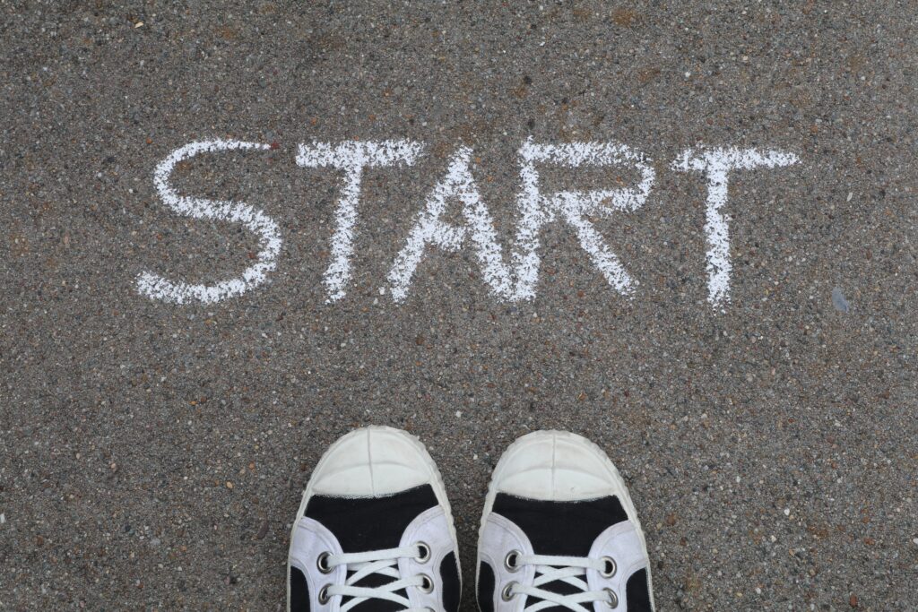 Looking down at "START" written in chalk on sidewalk, with shoes of photographer under it.